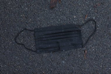 Yerde tek kullanımlık siyah bir maske vardı. Maske kirli ve siyah saplı. İhmal ve hijyene saygısızlık kavramı