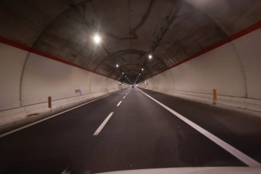 İçinde yol olan bir tünel. Tünel karanlık ve yol aydınlık.