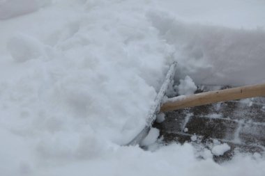 Kar küreği kaldırımdan kar temizlemek için kullanılıyor. Kar üst üste yığıldı ve kürek onu kenara itmek için kullanılıyor. Sıkı çalışma ve kararlılık kavramı