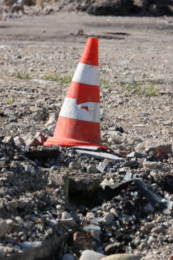 Toprağın içinde bir koni oturuyor. Bu bir trafik konisi. Koni kırılmış ve içinde bir delik var.. .