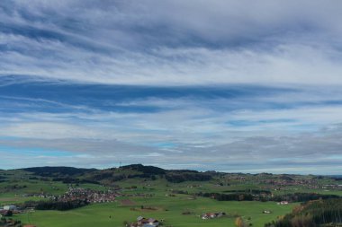 Güzel, berrak mavi gökyüzü ve birkaç bulutu olan sakin bir manzara. Gökyüzü uzaktan uçan kuşlarla doludur. Sahne huzurlu ve huzur verici, huzur ve ahenkle dolu.