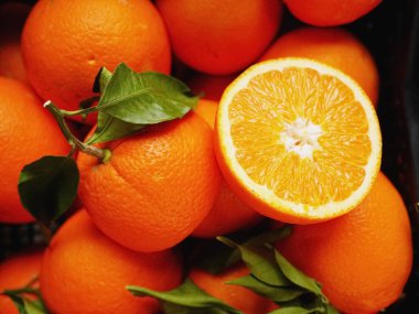 Tek kesikle bir sürü portakal. Portakallar taze ve olgun. Açık turuncu renk ilgi odağı, izleyicilerin dikkatini çekiyor.