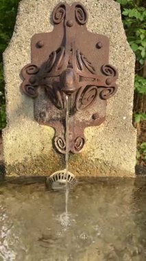 Büyüleyici bir görüntü, güzel dekoratif bir su çeşmesini berrak ve nazikçe akan suyla sergiliyor.