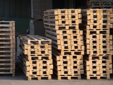 Ahşap paletler üst üste yığılmış. Paletler öyle bir istiflenmiş ki birbirlerine yaslanıyorlar.