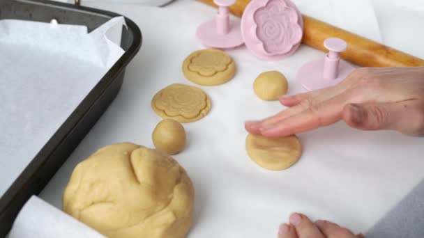 花の形でプレス形状のクッキーを作るプロセス 圧延ピンとトレイ 自宅で焼く料理の概念 女の子の手は ロールアウト生地からビスケットを作り 押すとそれを形作る — ストック動画