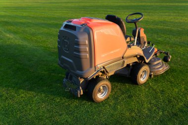 Dubno, Ukrayna-22 Eylül 2021: Futbol sahasının sonbahar bakımı. Spor sahasındaki çim biçme makinesi, işçi uzaklaştı.