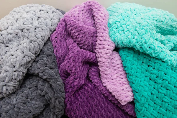 Beautiful plush multi-colored blankets of different colors lie together. Close-up