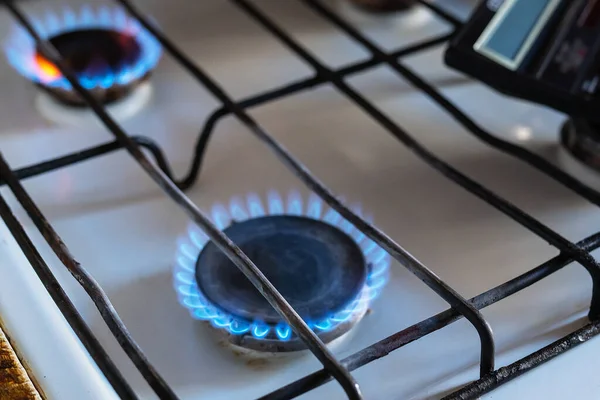 Gas is burning in the burner of the kitchen stove. Energy crisis. High cost, the price of gas