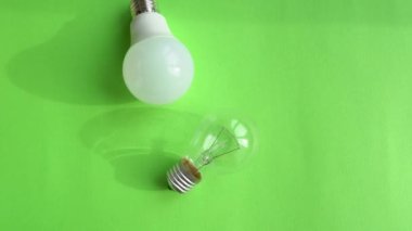 Energy saving diode lamp compared to a classic glass tungsten filament lamp close up. Technology development in bulbs - old incandescent bulb and modern energy saving eco friendly LED light bulb. 4k