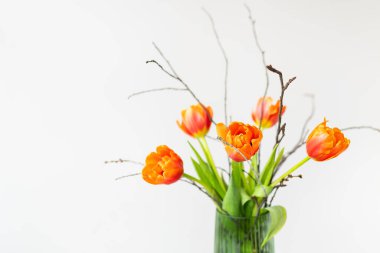 Yeşil bir vazoda çok güzel bir bahar buketi keten bir masa örtüsünün üzerinde duruyor, turuncu şakayık laleleri. Anneler Günü, 8 Mart, Sevgililer Günü. Bir yazıt için yer