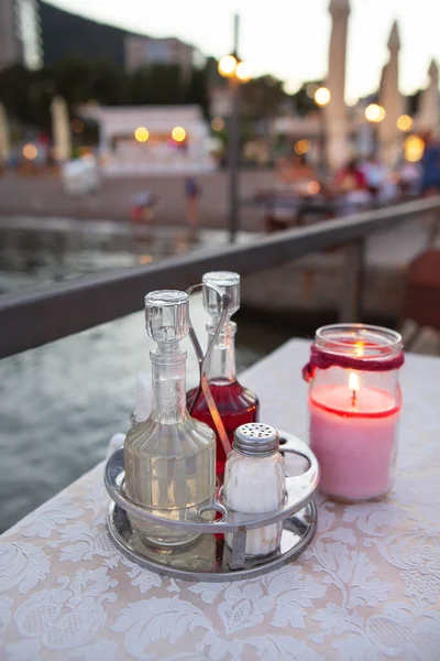 The terrace of the restaurant by the sea, there is a candle on the table. Against the backdrop of a beautiful resort town. Romantic dinner by the sea