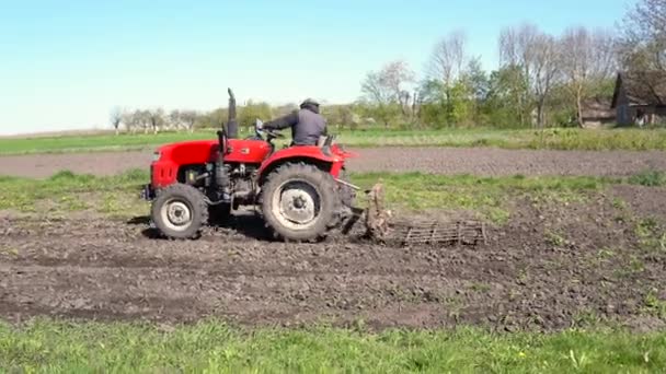 Landwirt Der Auf Einem Kleinen Roten Traktor Sitzt Lockert Den — Stockvideo