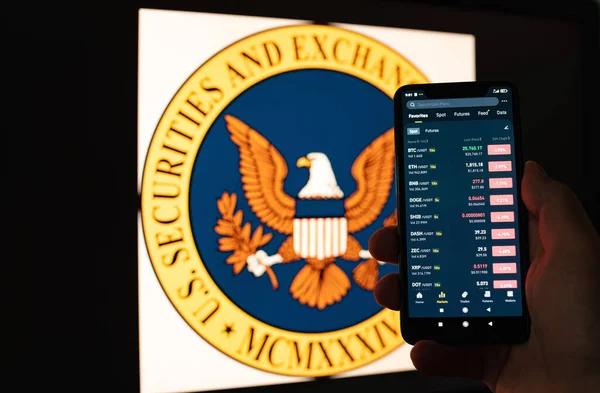乌克兰基辅 2023年6月6日 人类拥有一部带有加密货币报价的智能手机 其背景是带有Sec标志的监视器 加密货币的贬值 — 图库照片