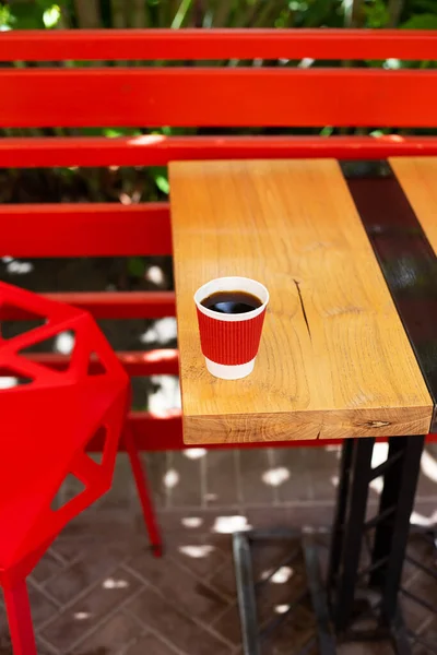 Een Houten Tafel Waarop Een Rode Plastic Beker Met Koffie — Stockfoto