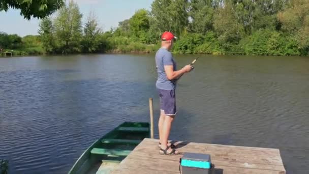Ein Fischer Steht Auf Einem Steg Der Nähe Des Wassers — Stockvideo