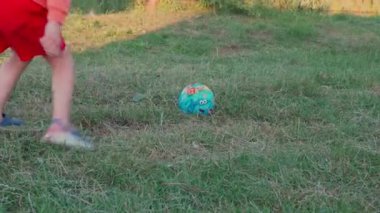 Çocuğa yakın dur ve topu çimlere sertçe vur. Dışarıda futbol oynayan tanınmayan sevimli çocuklar. Aktif hobisi olan ve futbol oynayan açık hava eğlencesi. 4K 'de insanlar video görüntüsü