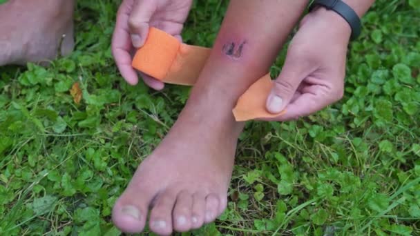 Bir Adam Bacağının Etrafına Turuncu Bir Bandaj Sarar Bir Yara — Stok video