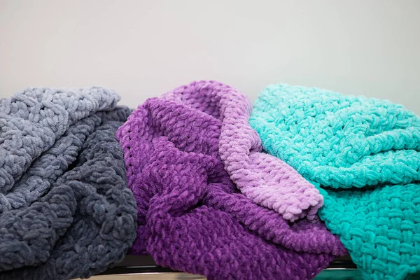 Beautiful plush multi-colored blankets of different colors lie together