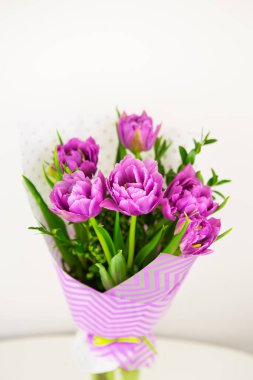 bouquet of beautiful violet lush tulips in a vase.