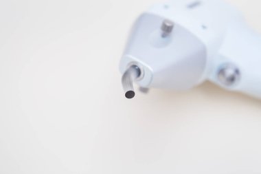 Aydınlık bir arkaplanda izole edilmiş beyaz bir lazer temizleme makinesinin yakın çekimi