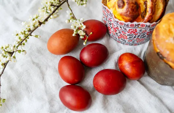 Festive Easter Setting Features Red Eggs Blossoms Pastries Textured Fabric — Stock Photo, Image