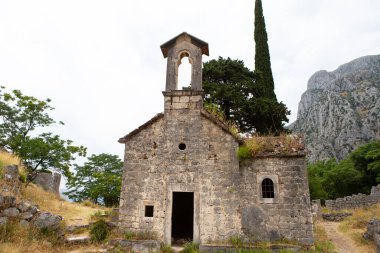 Karadağ 'daki dağlık bir manzaraya bakan yıkılmış taş kilise, yıpranmış güzelliğini ve tarihsel önemini gözler önüne seriyor..