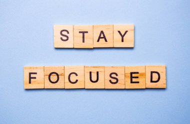 Tahta bloklar motivasyon mesajını kodlarken açık mavi bir arkaplana odaklan.