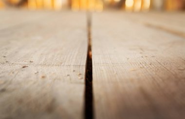 Yıpranmış ahşap bir yüzeyin yakın görüntüsü. Ortasında belirgin bir çatlak var..