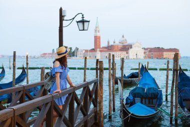 Güzel güneşli Venedik, kız köprüde duruyor gondolun yanında.