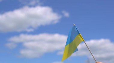 Ukrayna 'nın küçük bayrağı beyaz bulutlu mavi gökyüzüne doğru dalgalanıyor. Özgürlük ve bağımsızlığın sembolü. Ukrayna 'ya Destek.