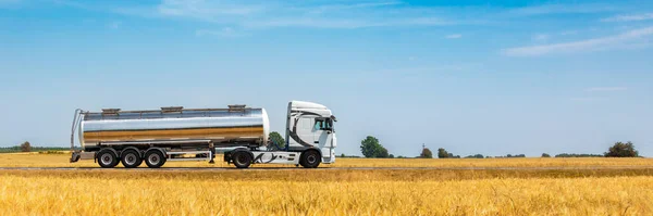Truck with oil tank on a wheat field in summer