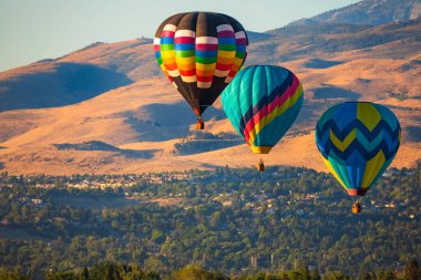 Dağların üzerinde uçan renkli sıcak hava balonları