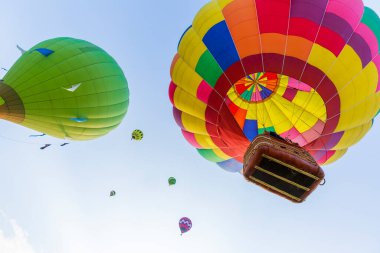 Festivalde mavi gökyüzünde uçan renkli sıcak hava balonları