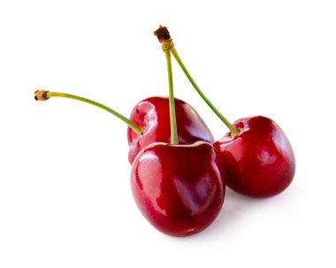 Kırmızı kirazlar beyaz arka planda izole edilmiş. Gölgeli stüdyo çekimi