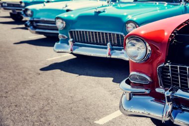 Sokaktaki bir araba fuarında peş peşe eski arabalar.