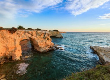 Uçurumlar, kayalık kemer ve yığında (faraglioni), Torre Sant Andrea, gündoğumu deniz manzarası: Salento deniz kenarı, Puglia, İtalya