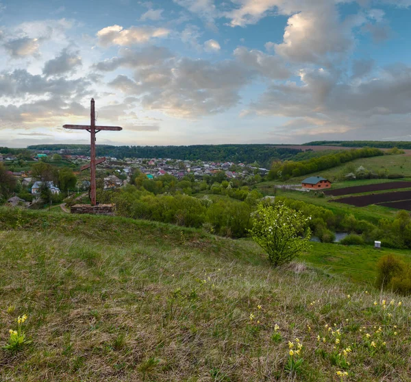 Wooden religious cross near Rukomysh Cave temple and spring country fields and village, Buchach District, Ternopil Region, Ukraine.