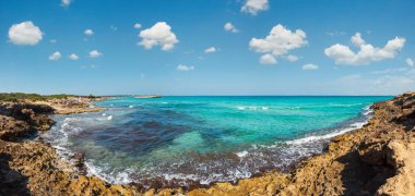 Pitoresk İyon deniz plajı Punta della Suina, Salento, Puglia, İtalya. Gelibolu şehir manzarası çok uzak. İnsanlar tanınmaz halde..