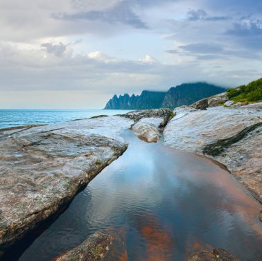 Yaz gecesi sahili. Ejderhanın dişleri kaya, Pürüzlü Ersfjord, Senja, Norveç .