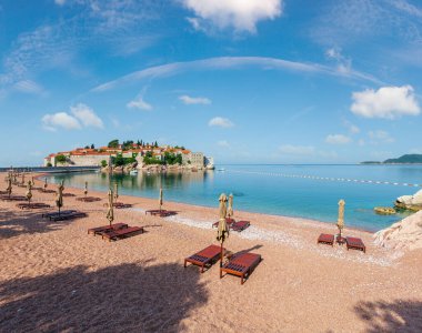 Pembe kumlu Milocher Beach ve Sveti Stefan adacık sabah görünümü (Karadağ, Budva yakınındaki). İnsanlar tanınmaz.