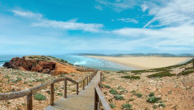 Summer Atlantic coast and lookout point at sandy beach Praia da Bordeira near river estuary. Misty view (Carrapateira, Algarve, Portugal).