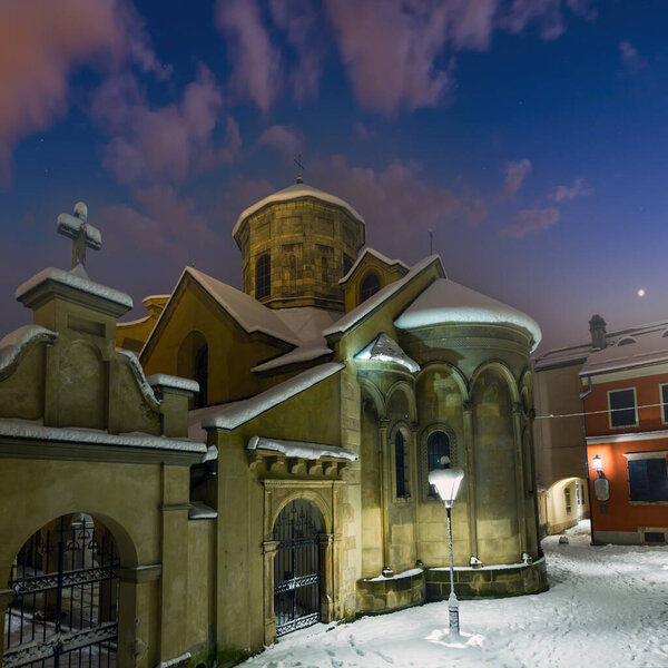 Ancient Armenian church in Lviv City, Ukraine. Beautiful evening twilight winter cityscape.
