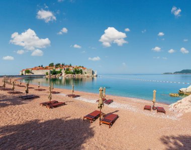 Pembe kumlu Milocher Beach ve Sveti Stefan adacık sabah görünümü (Karadağ, Budva yakınındaki). İnsanlar tanınmaz.