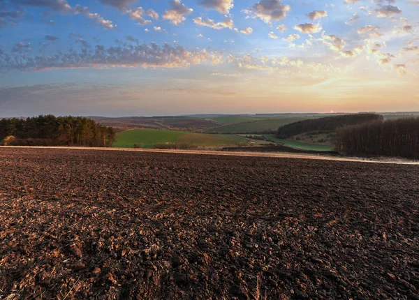 春の農村田舎風景耕された丘 谷の畑に農業分野の朝 柔らかく繊細な日の出の光で農耕と成長の農地 — ストック写真