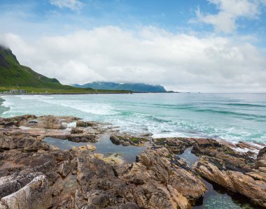 Ramberg (Norveç, Lofoten) taşlı Beach'te yaz bulutlu görünümünü. İnsanlar tanınmaz.