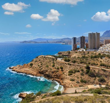 Gökdelenler kayalık sahil üzerinde. Benidorm şehir sahil şeridi yaz görünüm (Costa Blanca, Alicante, İspanya).