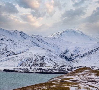 Güney İzlanda 'da mevsim değişiyor. Sonbaharda kar altında renkli Landmannalaugar dağları. Dağın eteğindeki Frostastadavatn Gölü.