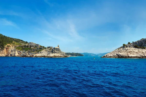 stock image Beautiful medieval fisherman town of Portovenere (UNESCO Heritage Site) view from sea (near Cinque Terre, Liguria, Italy). Fortress Castello Doria and church Chiesa di San Pietro.