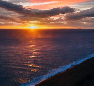 Dyrholaey Burnu, Vik, Güney İzlanda 'dan sonsuz okyanus siyah volkanik kumsal manzarası. Vestmannaeyjar Adaları Ufukta garip siluetler.