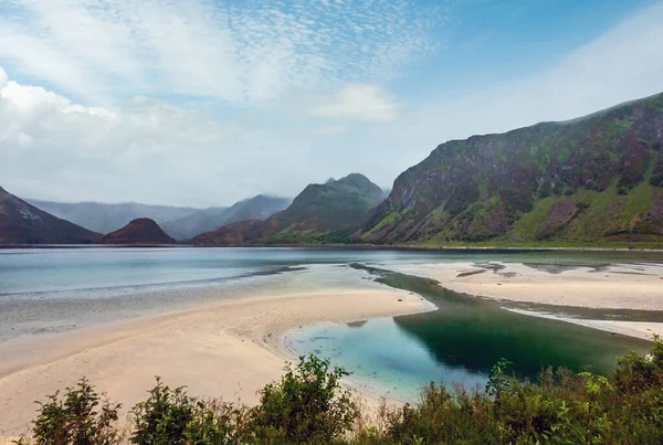 Lofoten fiyortları ve göller bulutlu, yatay, kumlu plaj, gülmek ve dağlar (Norveç). Yaz kutup gün gece görünümü.